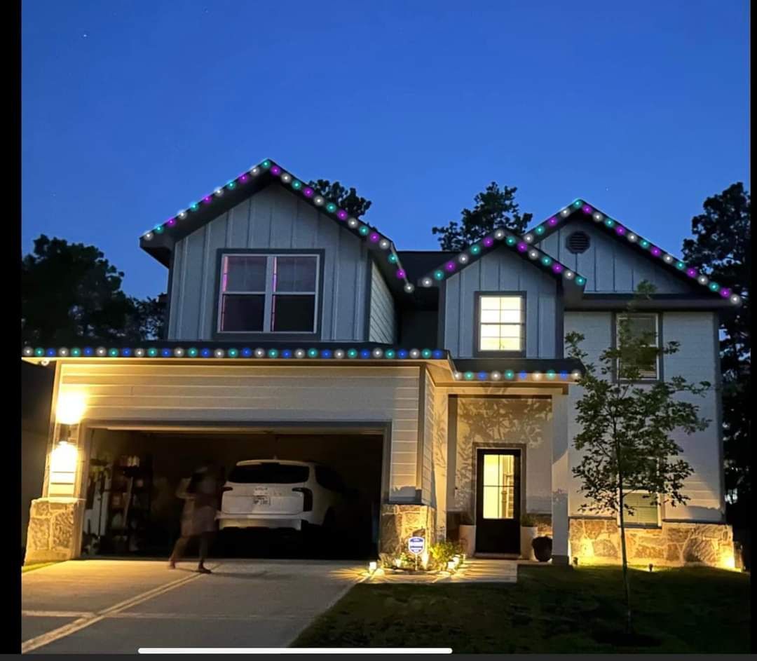 Two-story house with Christmas lights along the roof. A car is parked in the open garage.