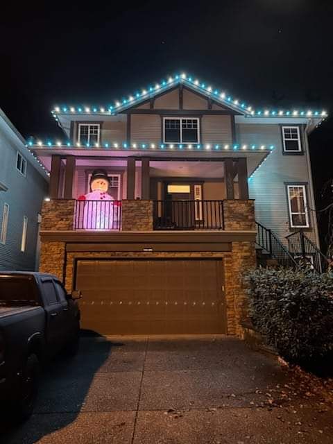 House decorated with Christmas lights and a snowman inflatable.
