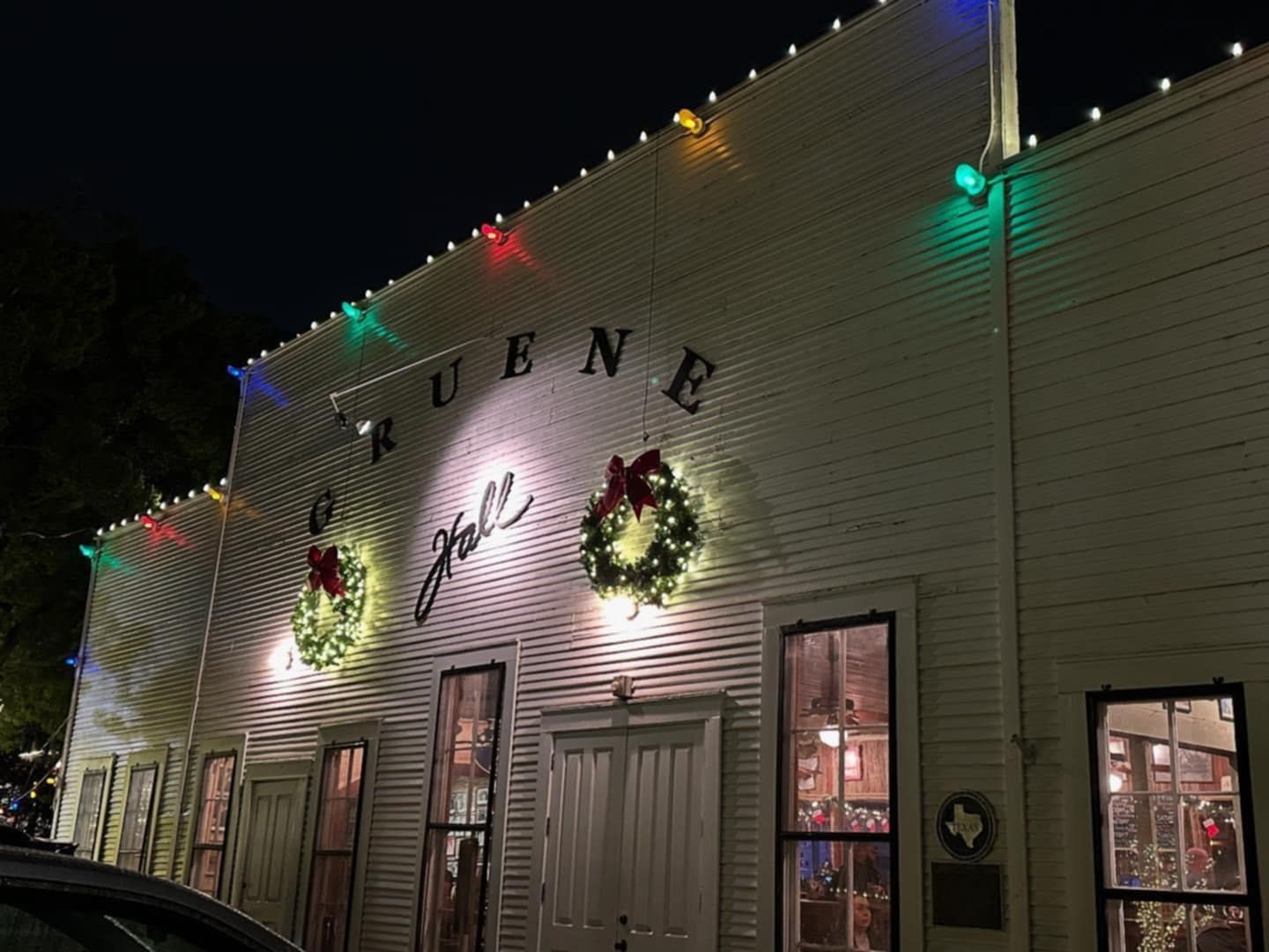 Gruene Hall at night, decorated with Christmas lights and wreaths.