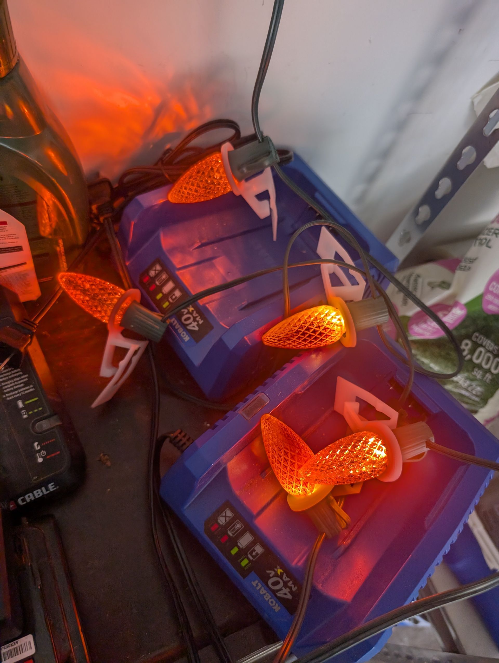 String of orange Christmas lights attached to blue containers.