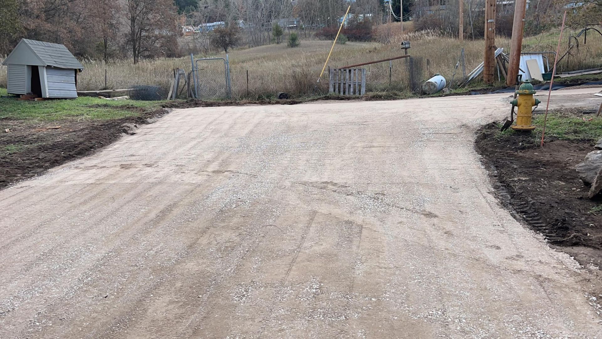 A dirt road with a fire hydrant on the side of it.