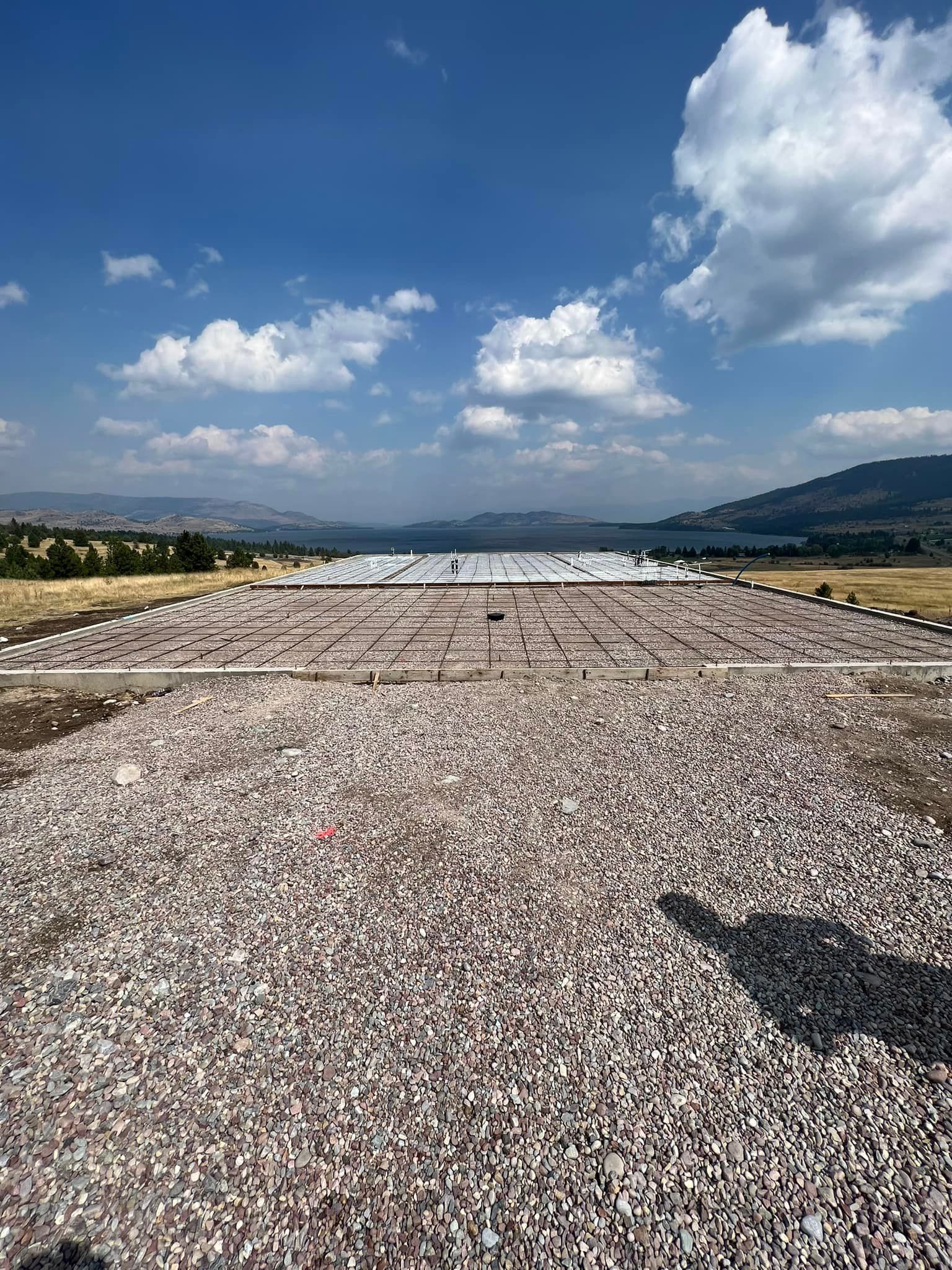 A large pile of gravel is sitting in the middle of a field.