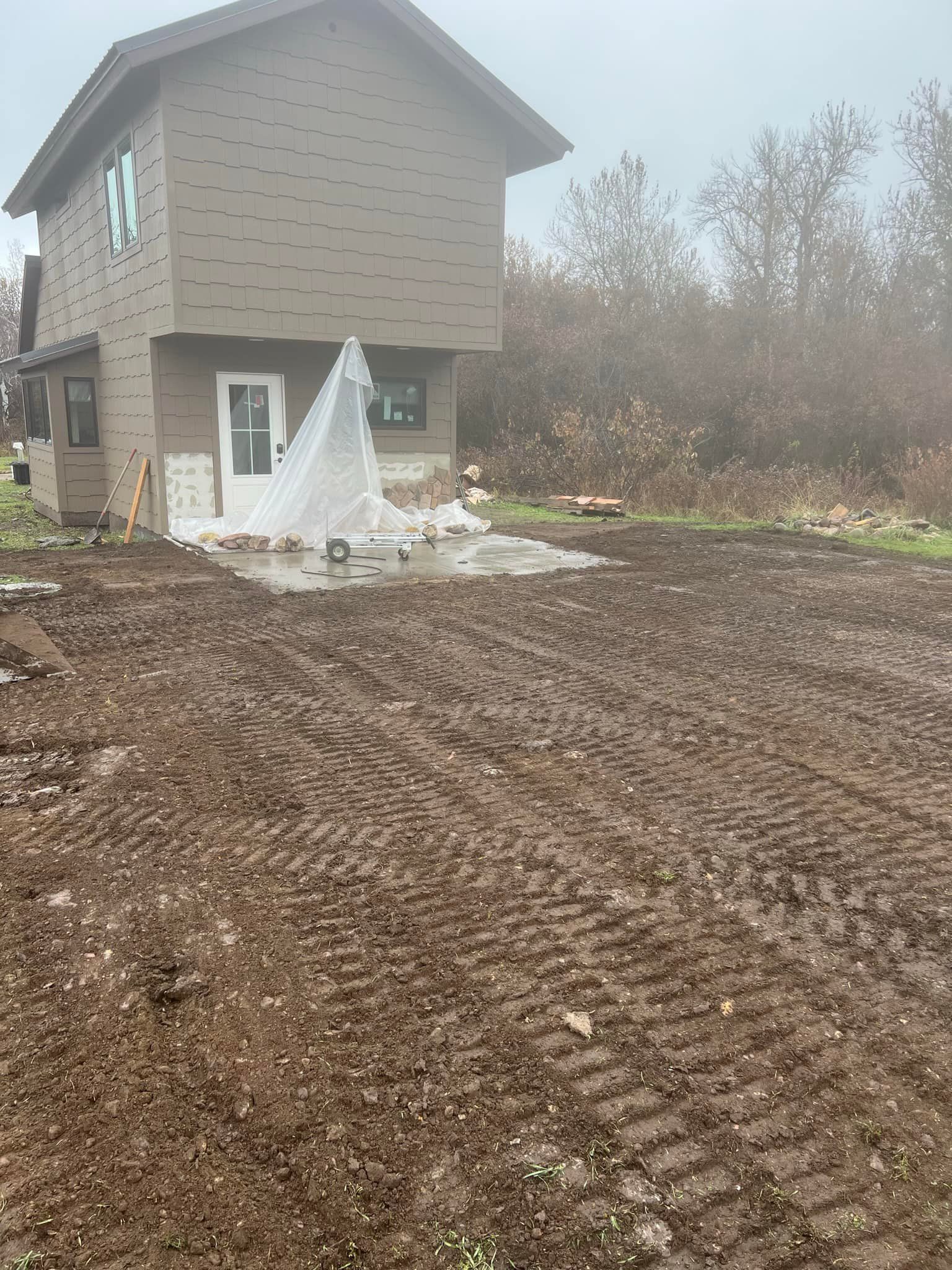 A house is sitting in the middle of a dirt field.