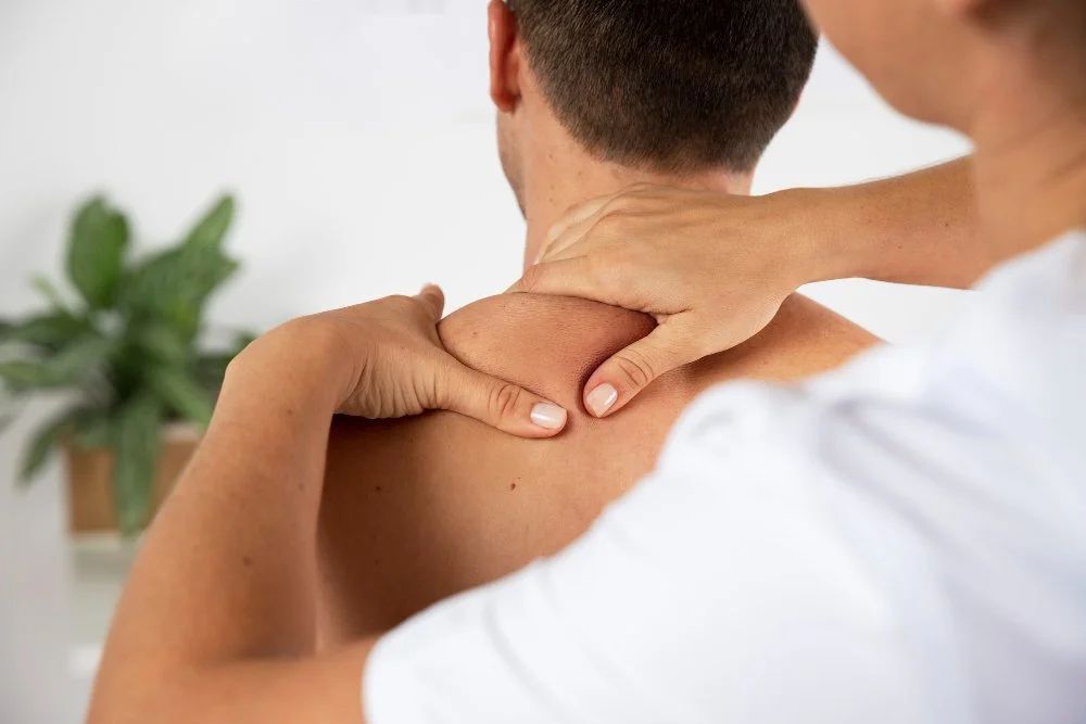 Woman receiving a head massage in a spa setting with candles and warm lighting.