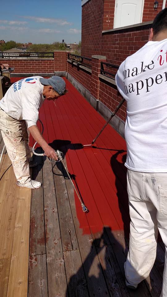 Men Are Spraying Red Paint on a Wooden Deck — Chicago, IL — McMaster Painting