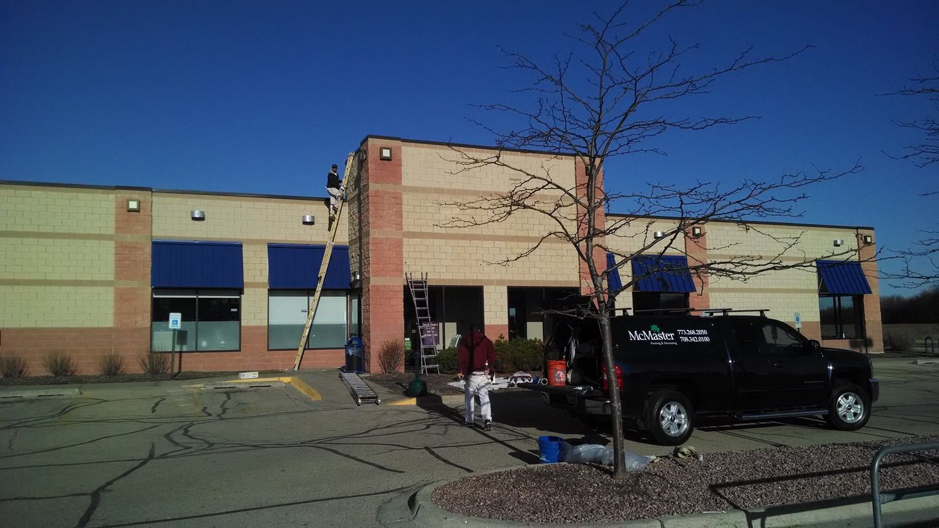 A Truck Is Parked In Front Of A Building That Is Being Painted — Chicago, IL — McMaster Painting