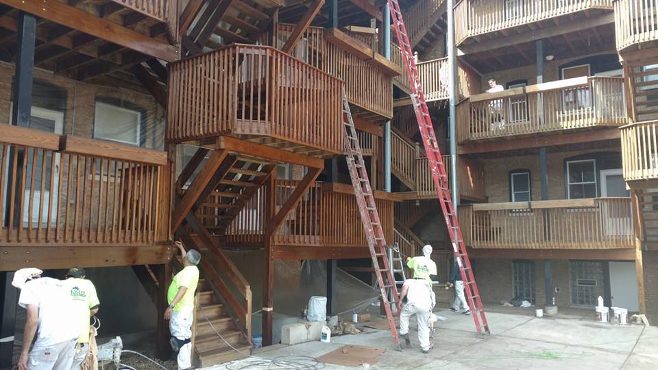 Group of Men Are Standing in Front of a Large Wooden Building — Chicago, IL — McMaster Painting