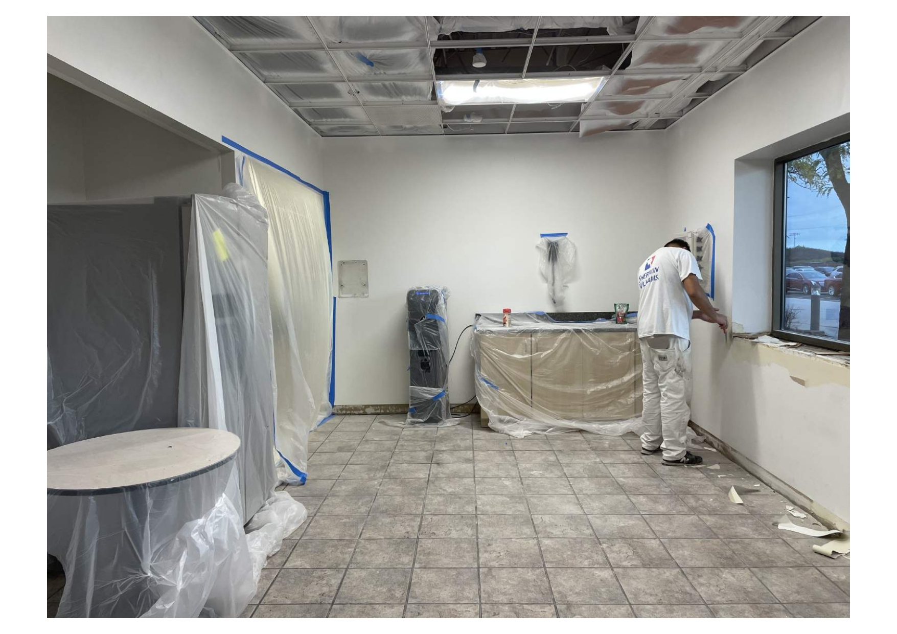 A Man Is Painting a Wall Near Window in An Empty Room - Chicago, IL - McMaster Painting