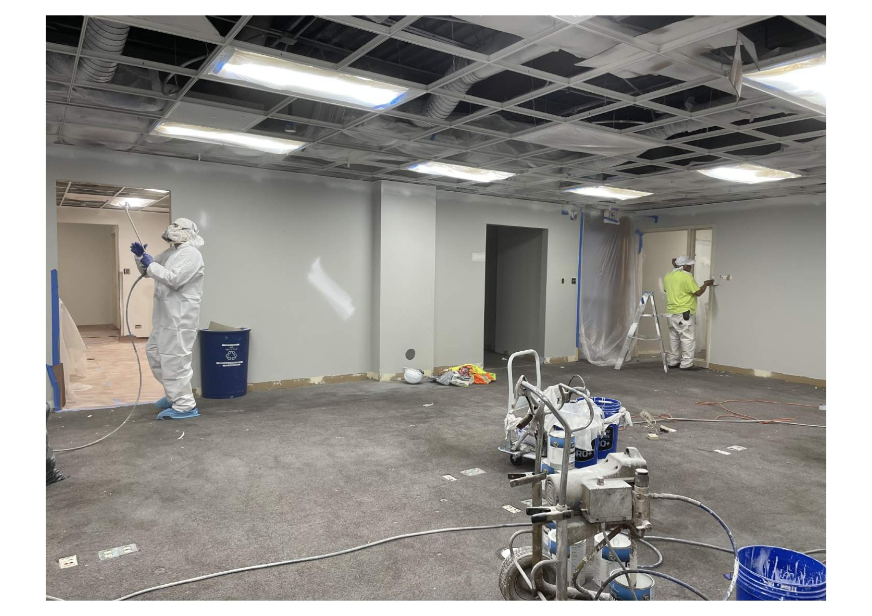A Man in A Protective Suit Is Painting a Wall in A Room - Chicago, IL - McMaster Painting
