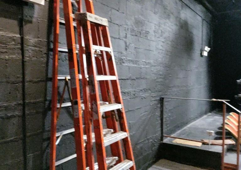 An Orange Ladder Is Leaning Against a Black Wall - Chicago, IL - McMaster Painting