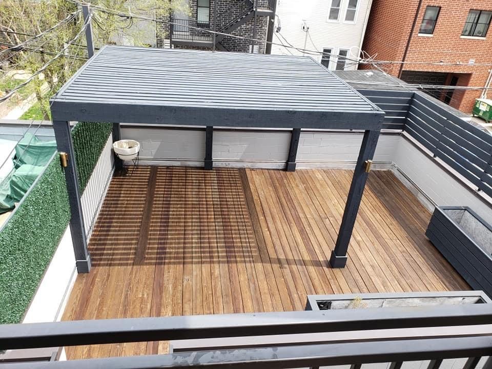 An aerial view of a rooftop deck with a pergola and a wooden floor — Chicago, IL — McMaster Painting	
