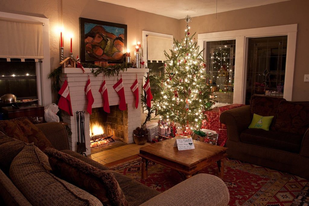 A living room decorated for christmas with a fireplace and a christmas tree