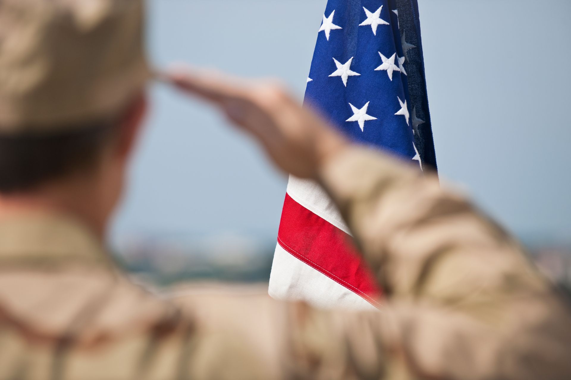 A soldier in uniform salutes, symbolizing honor, service, and military commitment.
