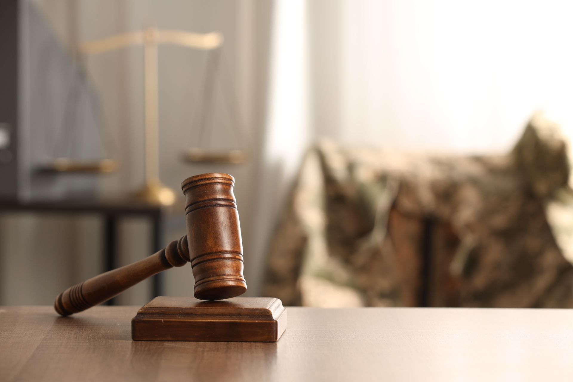 Wooden gavel placed on a table during an indoor legal consultation session.