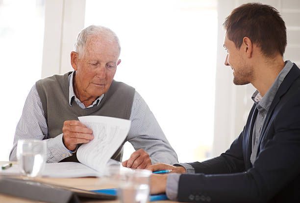 A young businessman explaining information to an elderly man.