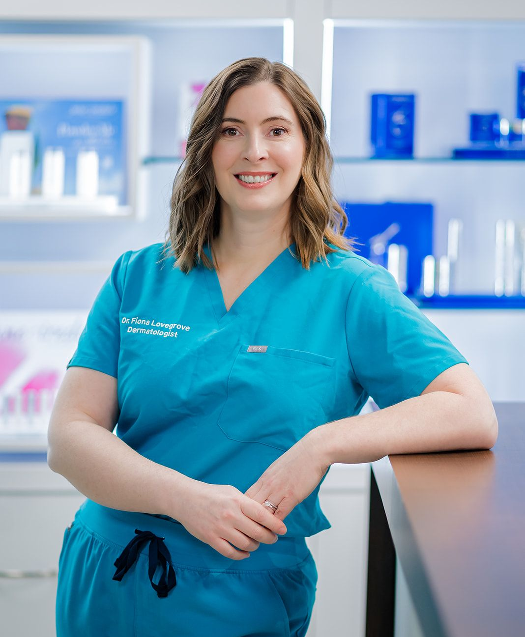 Dr. Fiona Lovegrove standing in clinic in front of skincare display