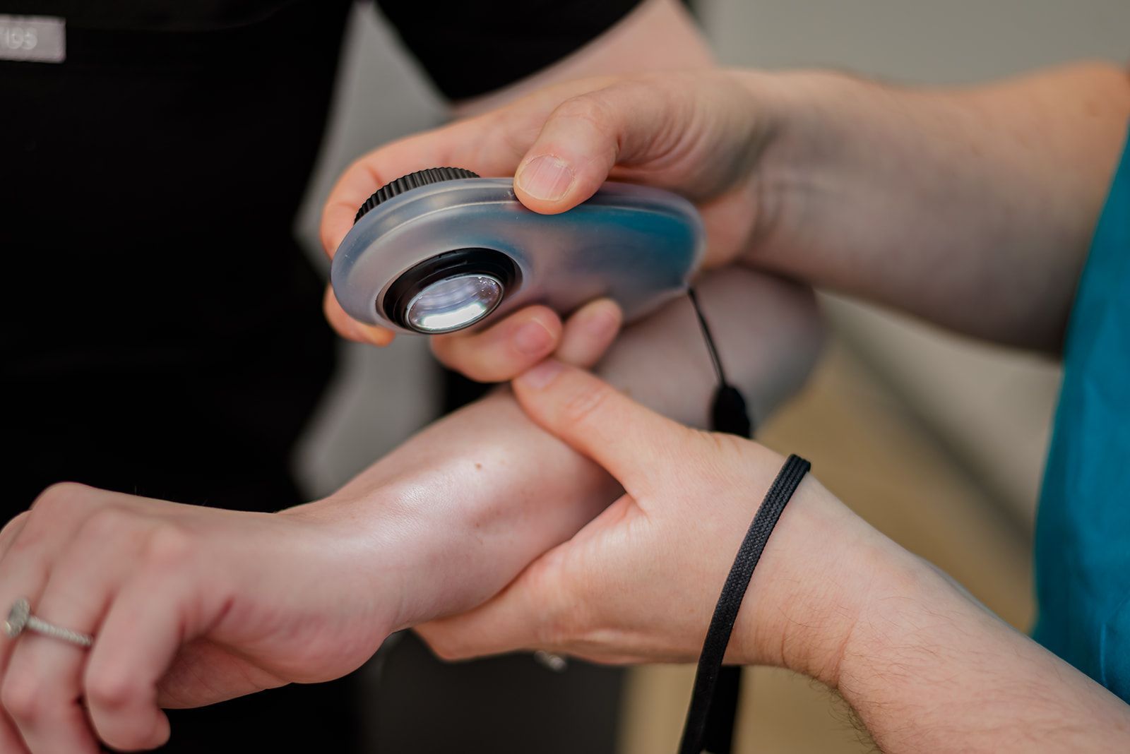 Dermatoloscope in dermatologist's hand. Assessing mole/lesion.