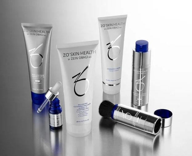 Various ZO Skin Health skincare products on a reflective surface.