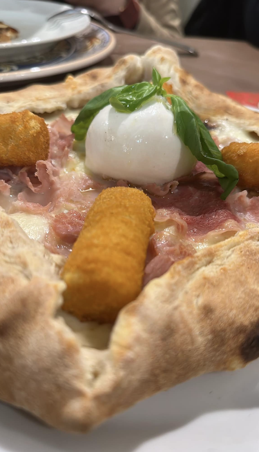 Un primo piano di una pizza su un piatto su un tavolo.