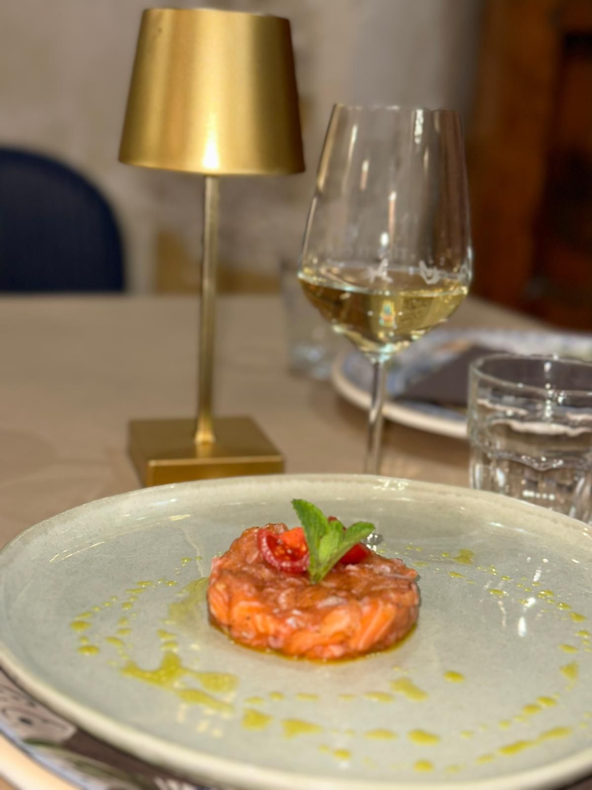 Un piatto di cibo e un bicchiere di vino su un tavolo.