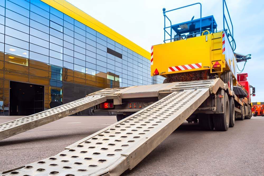 A Tow Truck With Ramps Attached To It Is Parked In Front Of A Building — Big Tim's Towing in Sandgate, NSW