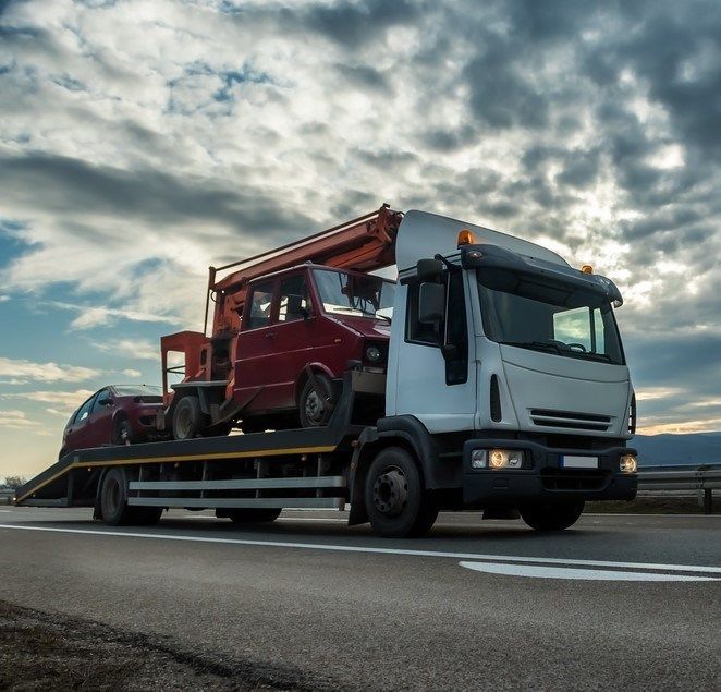 Two Vehicles Are Being Carried By A Tow Truck — Big Tim's Towing in Belmont, NSW