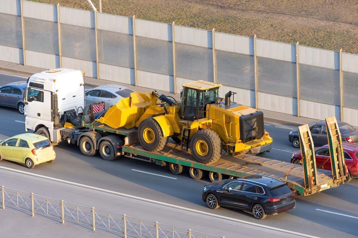 A Truck Is Towing The Heavy Machinery On The Highway — Big Tim's Towing in New Lambton, NSW