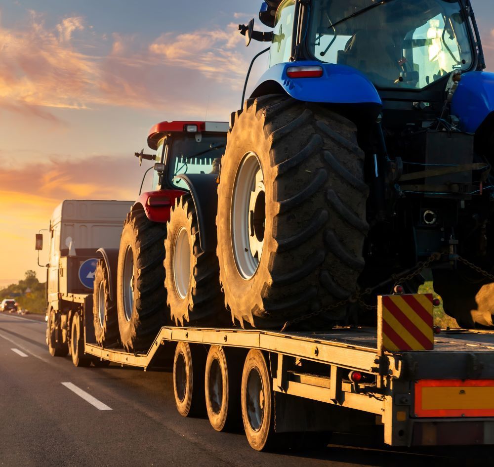 A Tractor Is On The Back Of A Trailer — Big Tim's Towing in Lambton, NSW