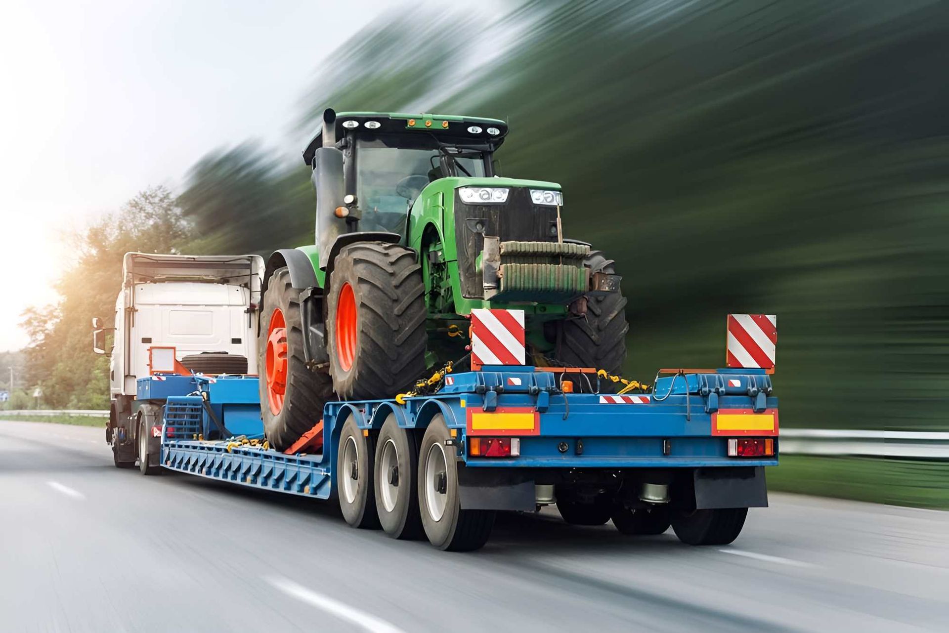 A Tractor Is Being Transported On A Trailer On A Highway — Big Tim's Towing in Port Stephens, NSW