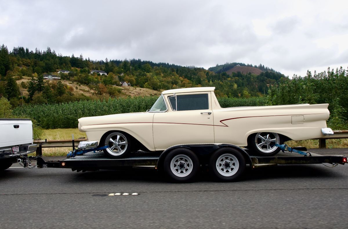 An Old Fashioned Long Off White Car Is Towed On The Highway — Big Tim's Towing in Black Hill, NSW