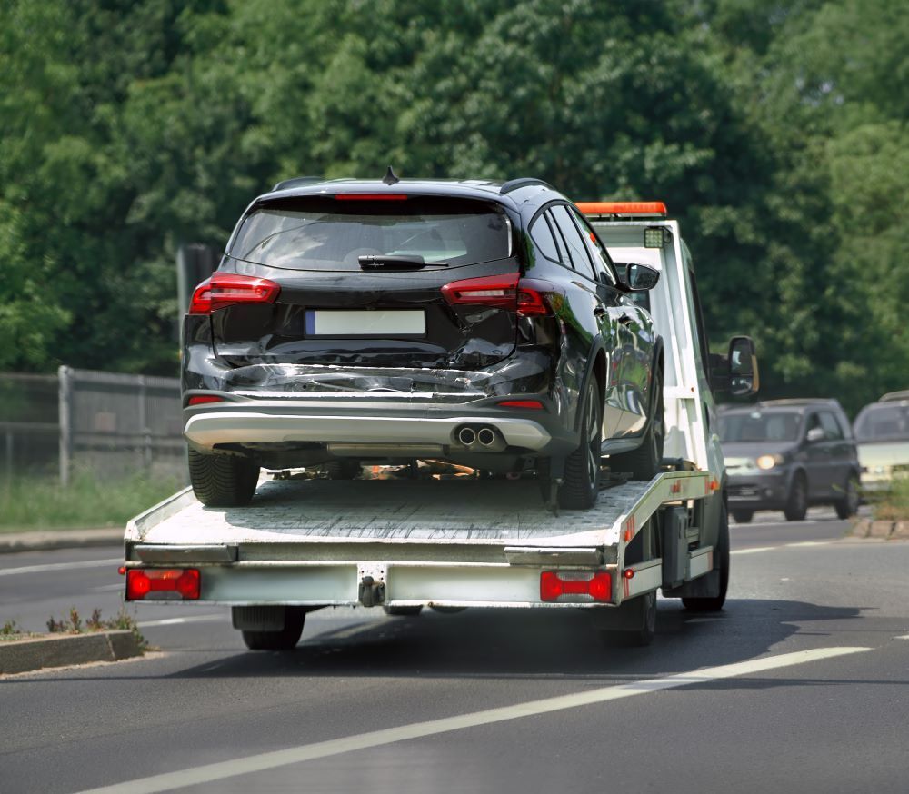 Wrecked Car Being Towed By Roadside Service — Big Tim's Towing in Wickham, NSW