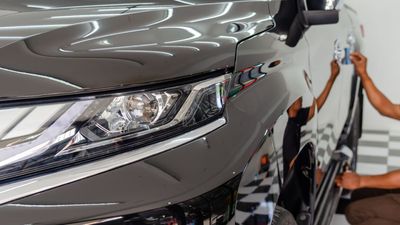 A man is polishing a car in a garage.