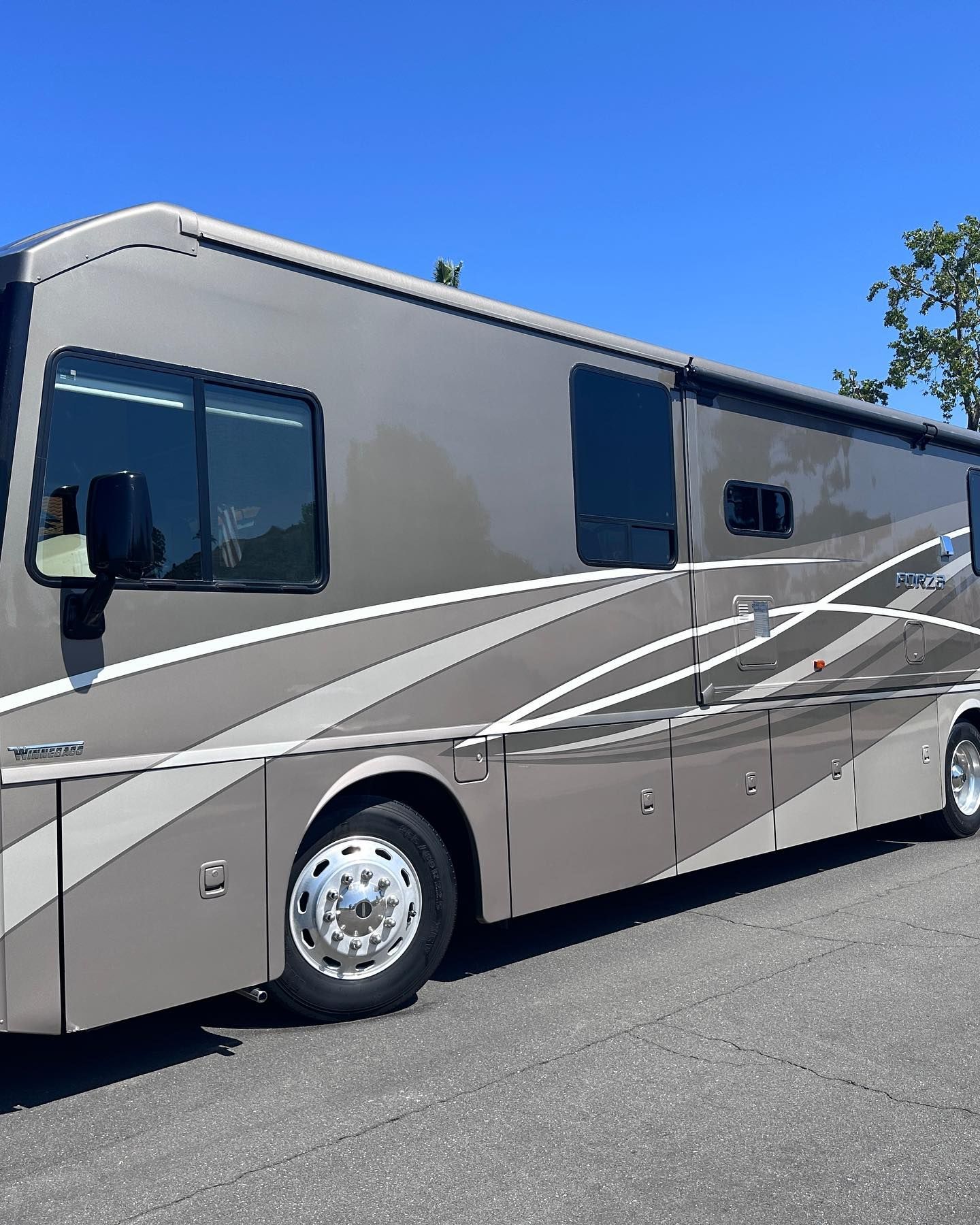 A large rv is parked on the side of the road.