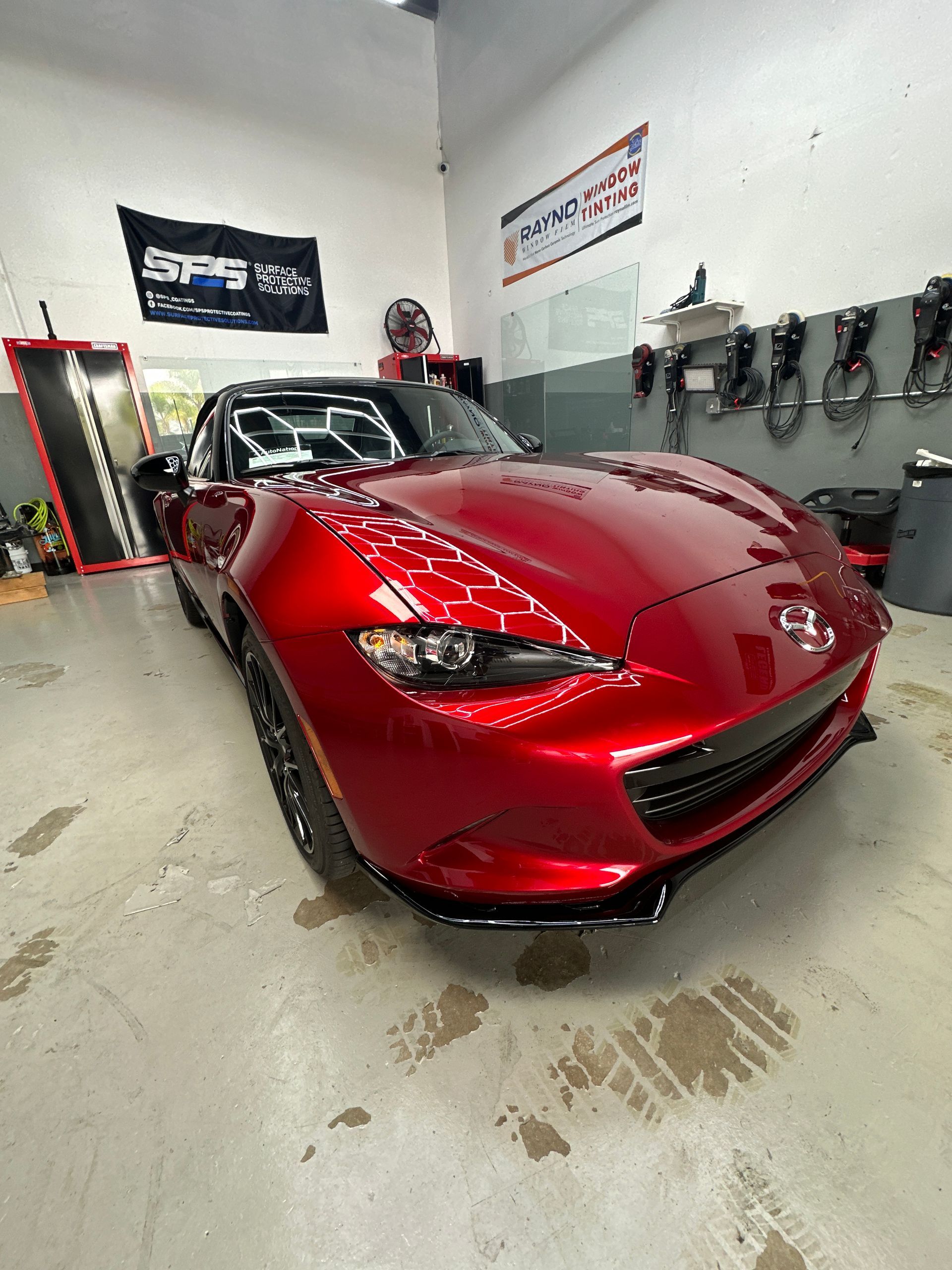 A red sports car is parked in a garage.
