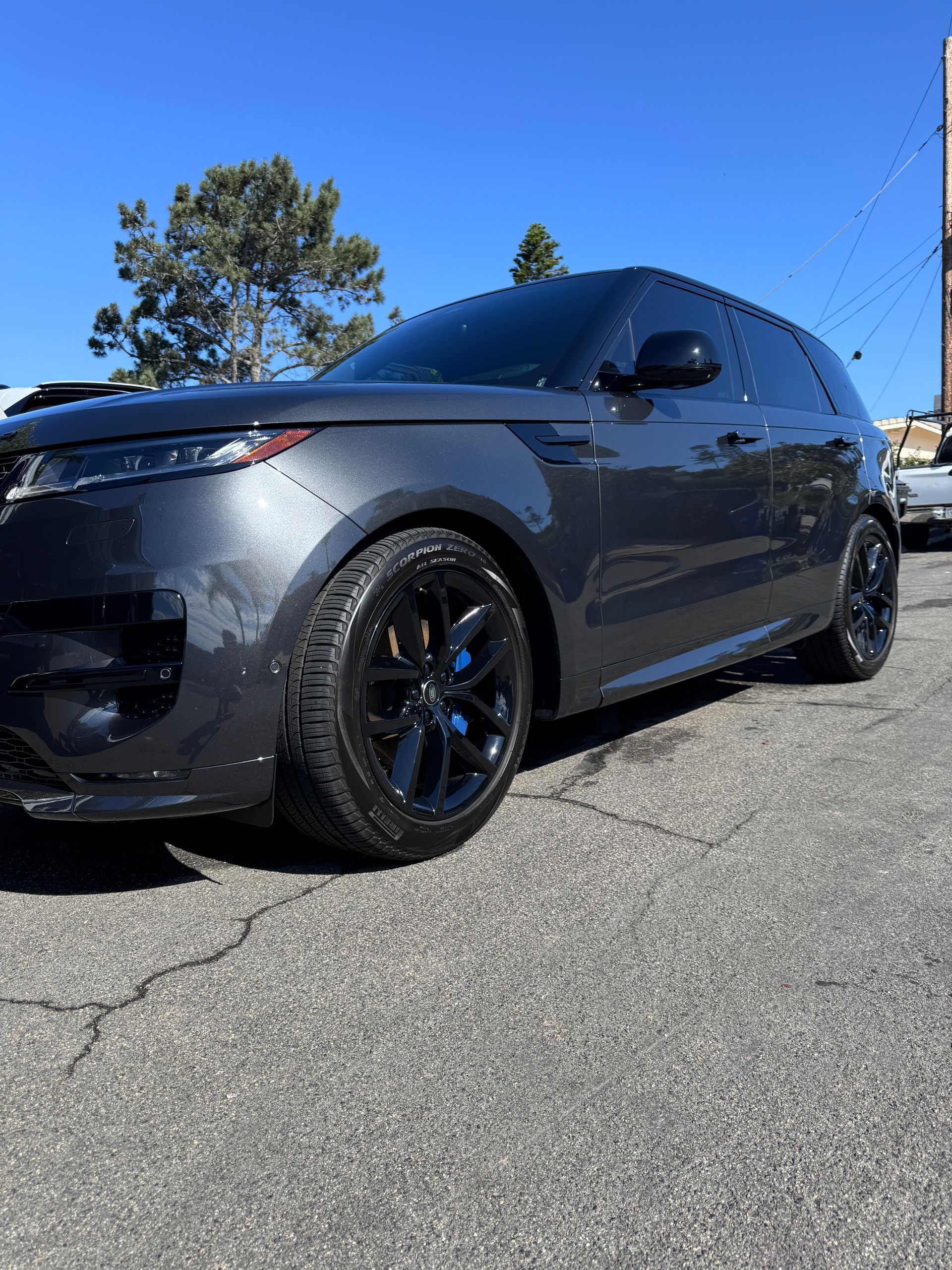 A gray car is parked on the side of the road.