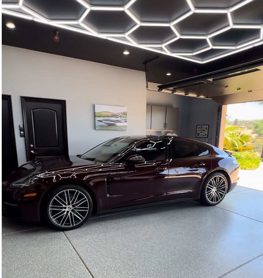 A car is parked in a garage under a honeycomb ceiling