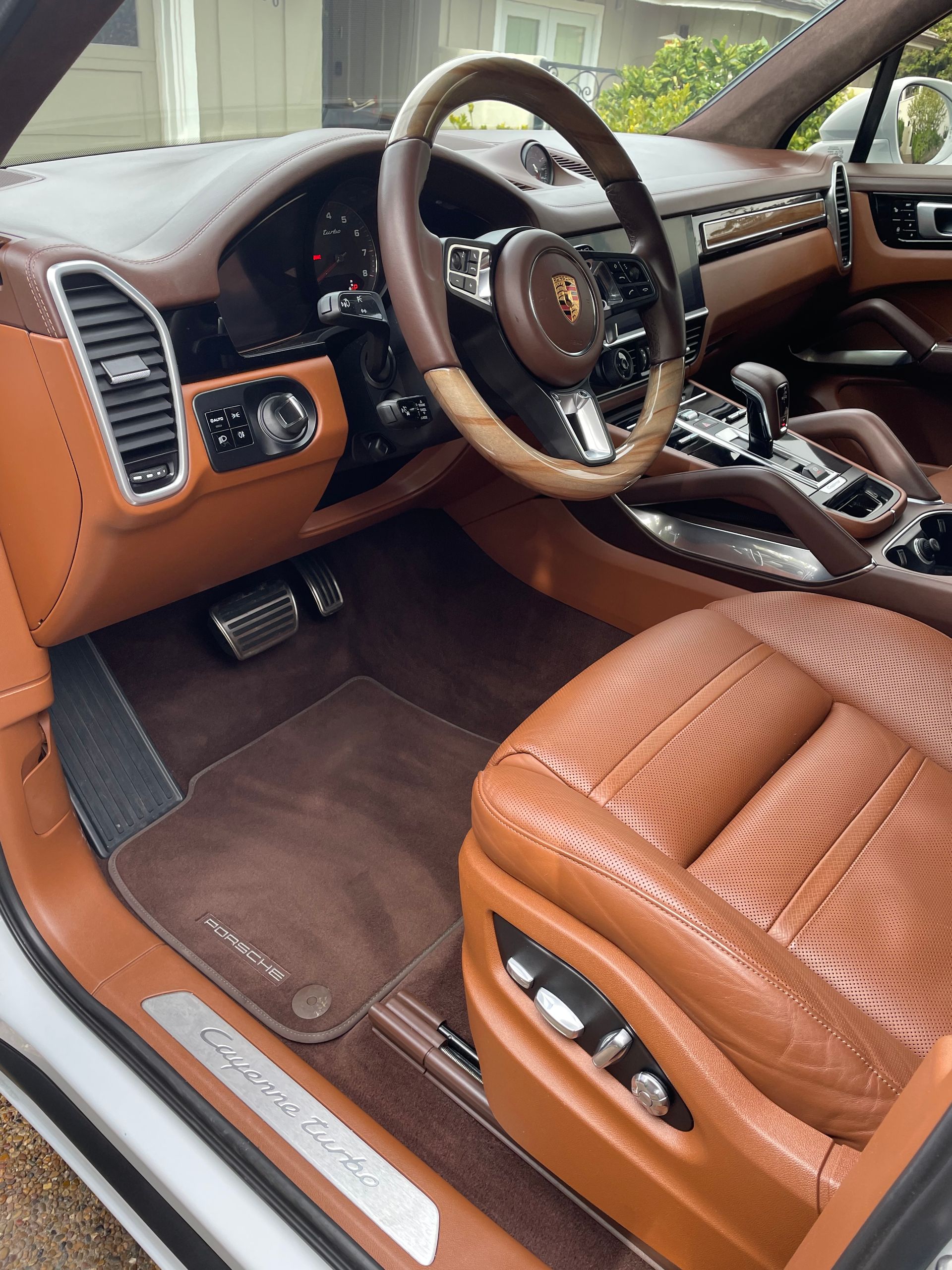 The interior of a porsche cayenne with brown leather seats