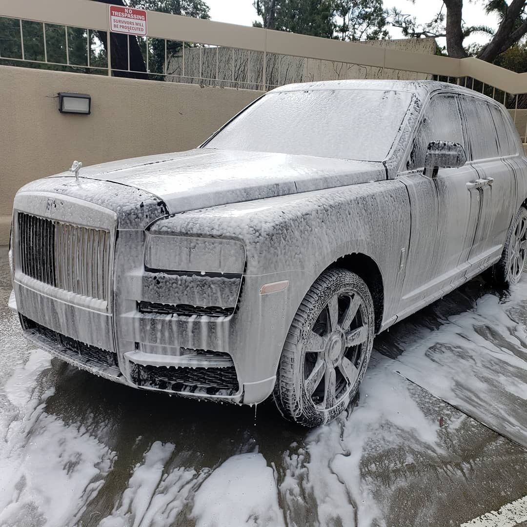 A car covered in foam is parked in a parking lot