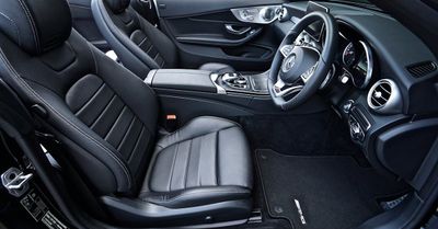 The interior of a black car with leather seats and a steering wheel.