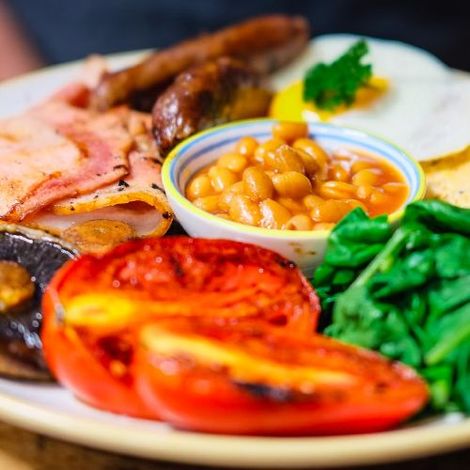 A close up of a plate of food with beans tomatoes and spinach