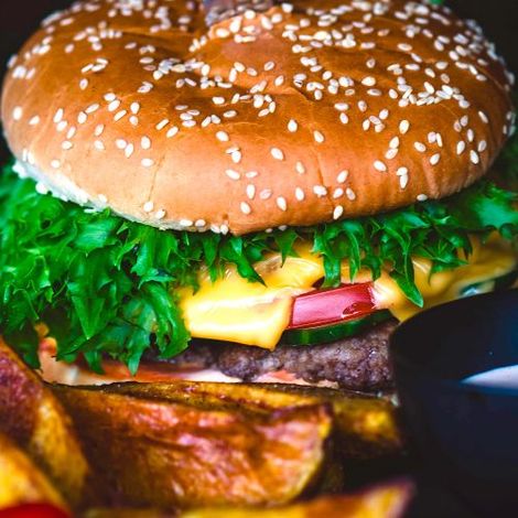 A close up of a hamburger and french fries on a table.