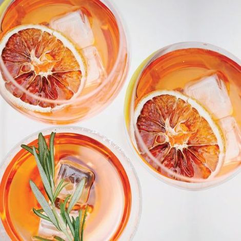 Three glasses of orange juice with ice and orange slices