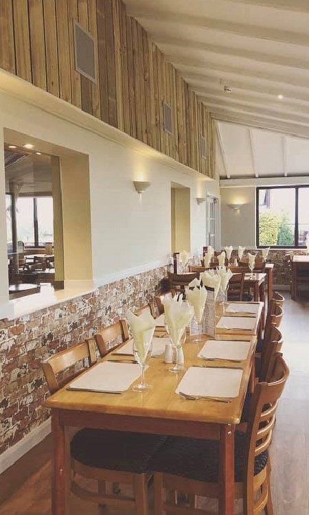 A restaurant with tables and chairs set up for a meal.