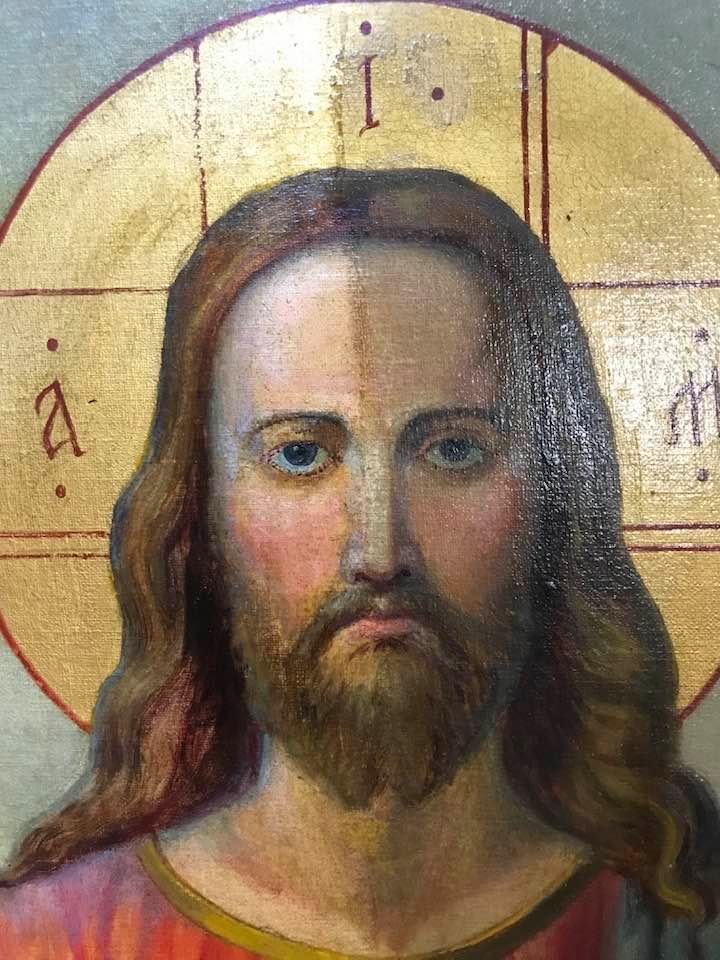 A close up of a painting of jesus with long hair and a beard.