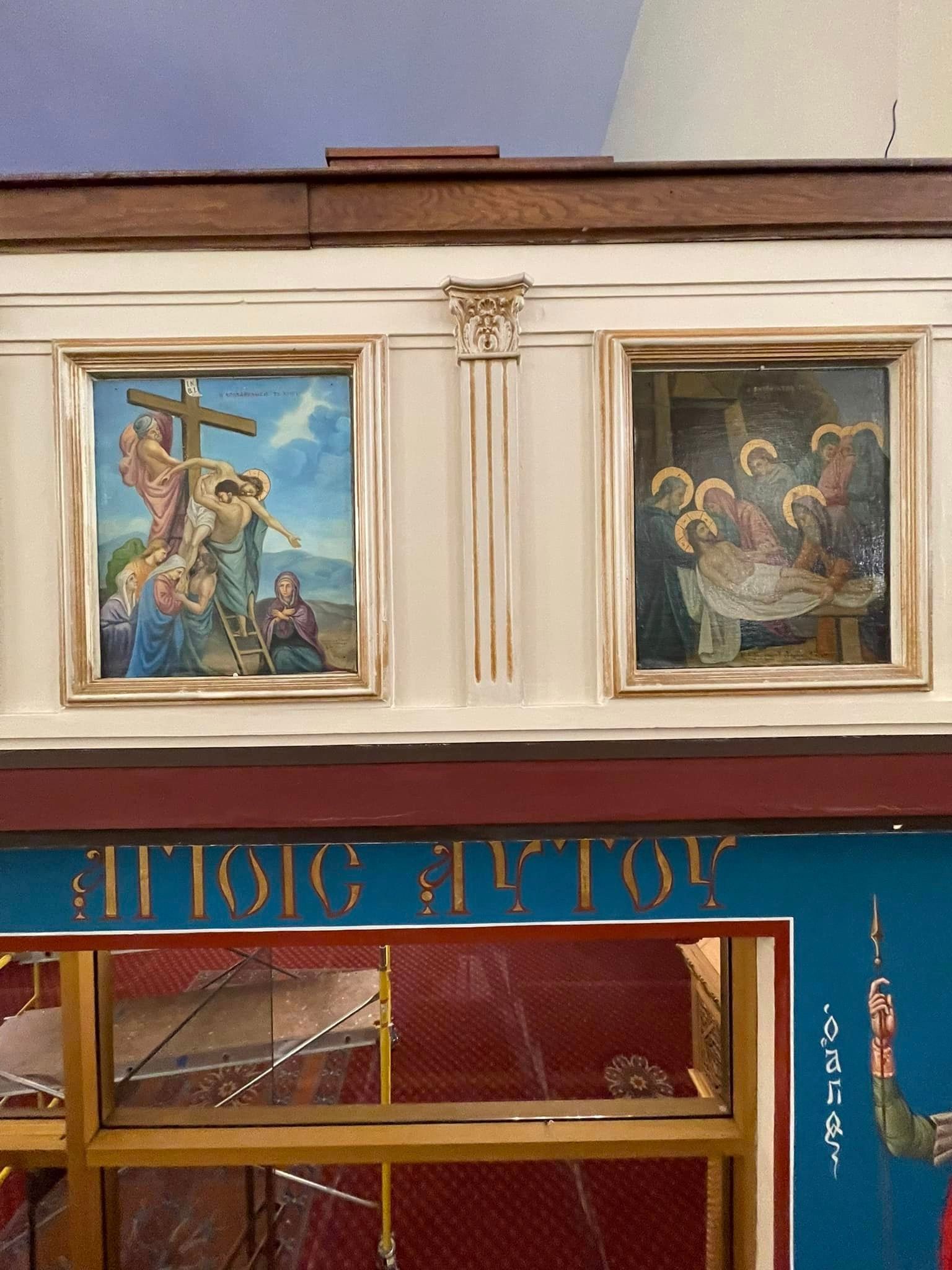 Two paintings on the side of a building one of which is of jesus carrying a cross
