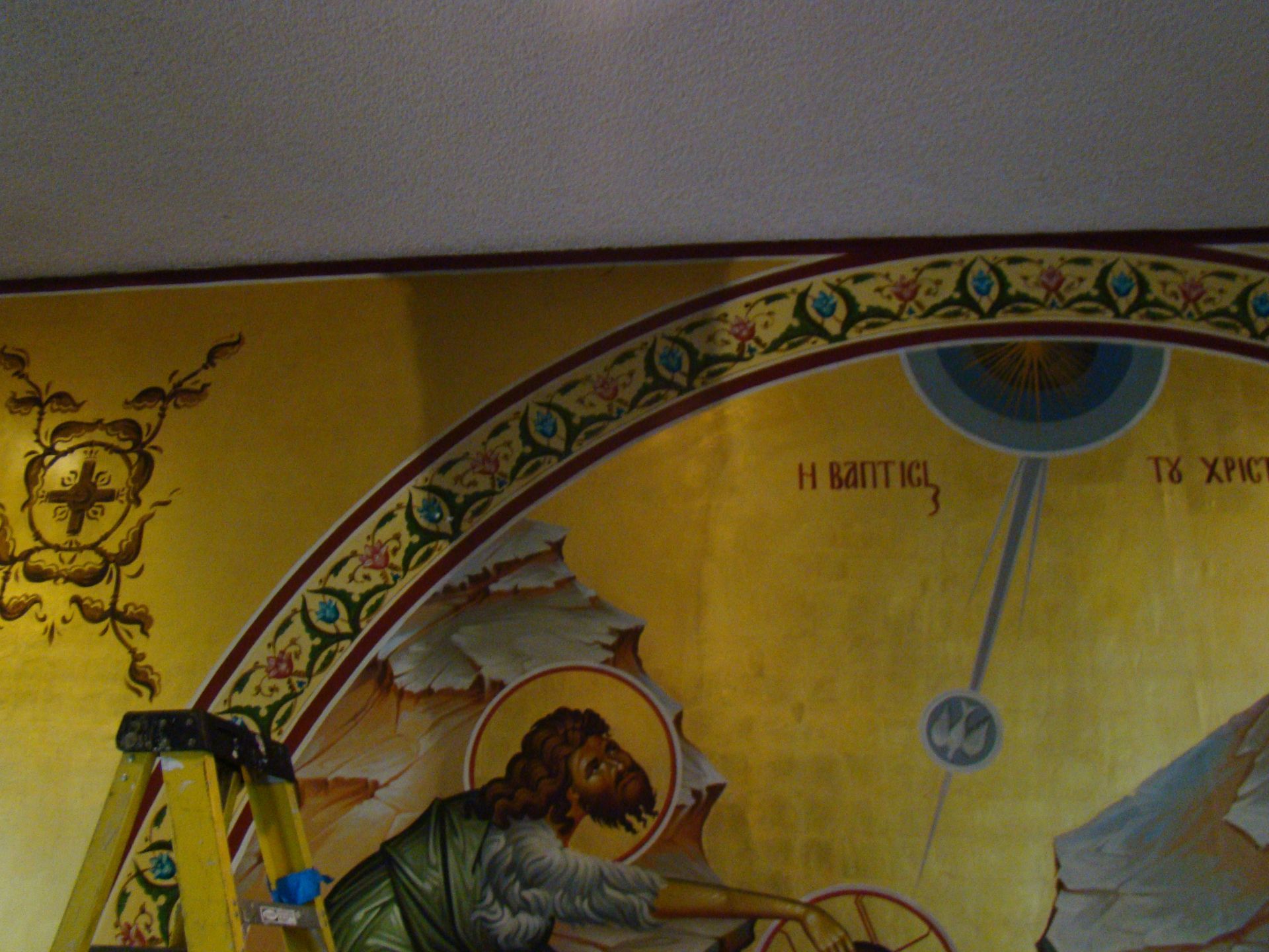 A ladder sits in front of a painting of jesus