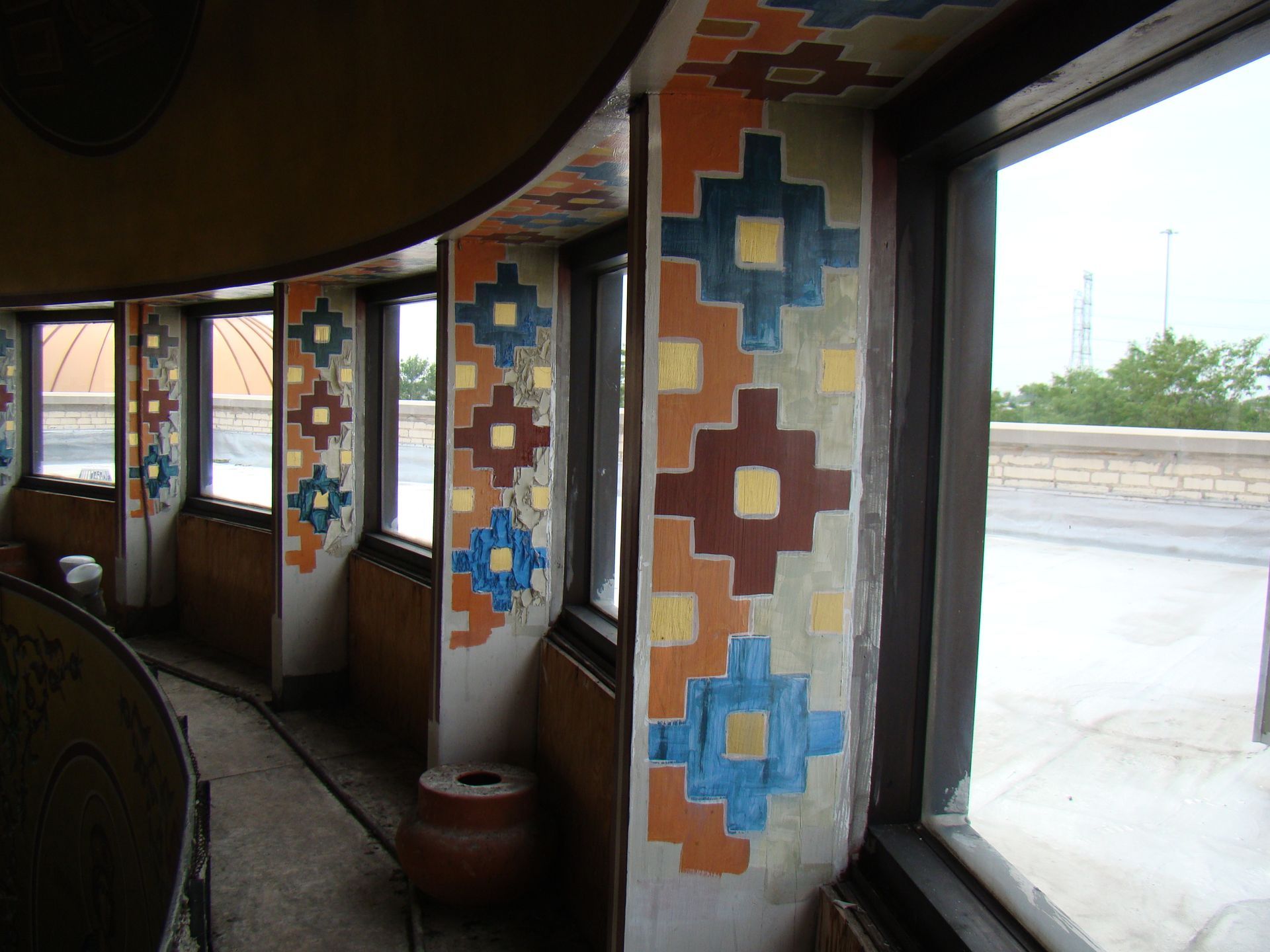 A room with a lot of windows and a painting on the wall