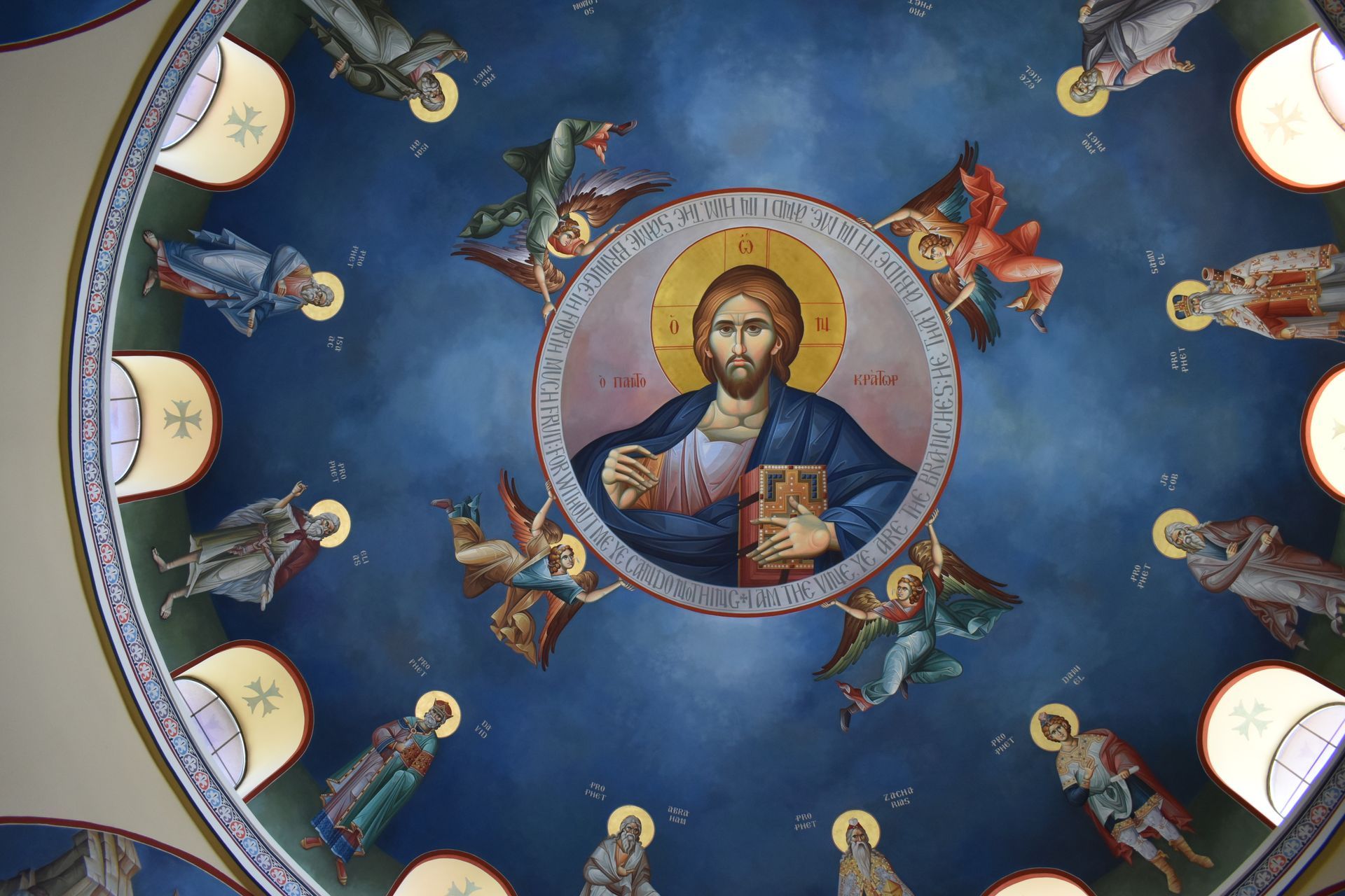 A painting of jesus surrounded by angels on the ceiling of a church