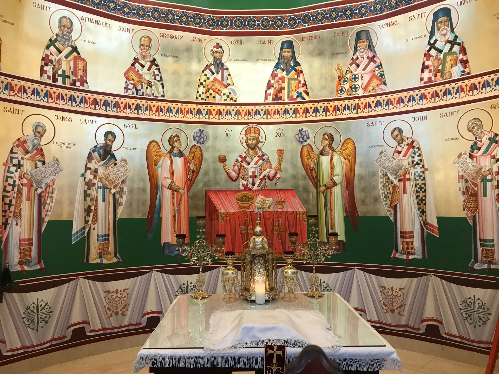 A church with a painting of jesus and angels on the wall.