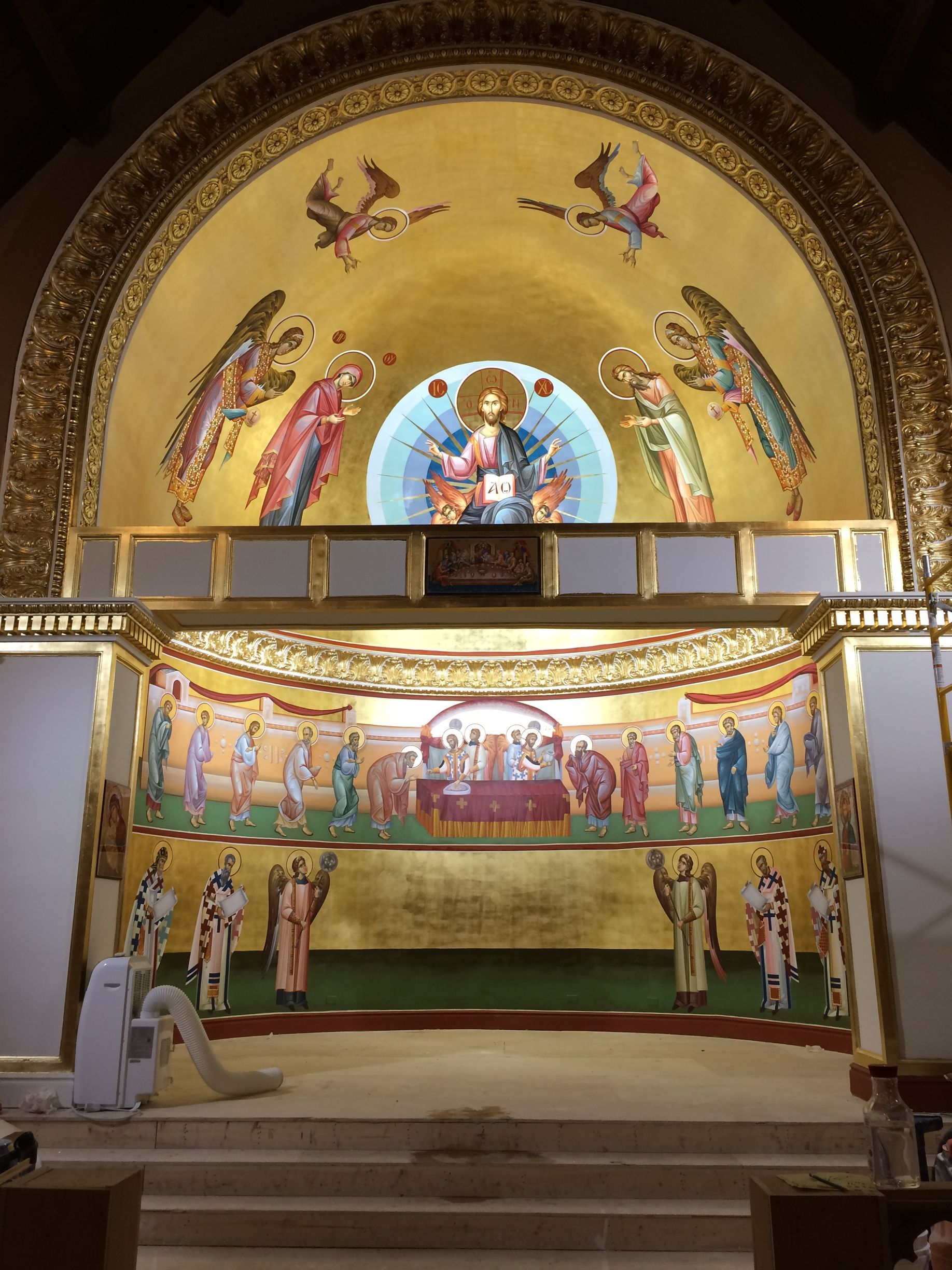 A church with a large painting of jesus on the altar.